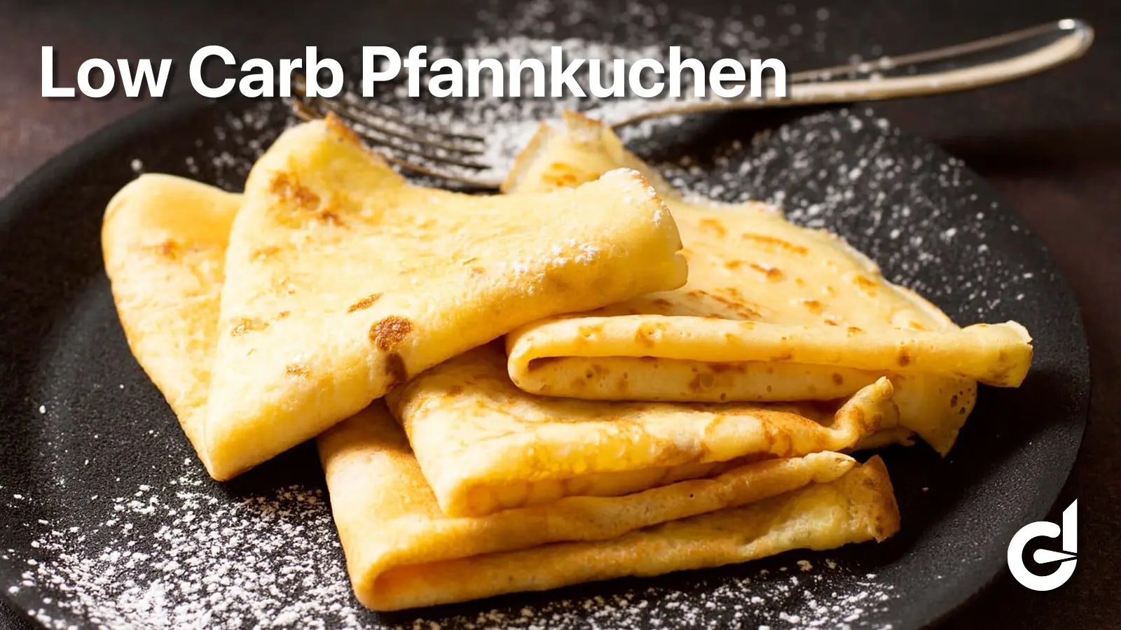 Rezept für Low Carb Pfannkuchen - Pfannkuchen mit Puderzucker auf einem schwarzen Teller.