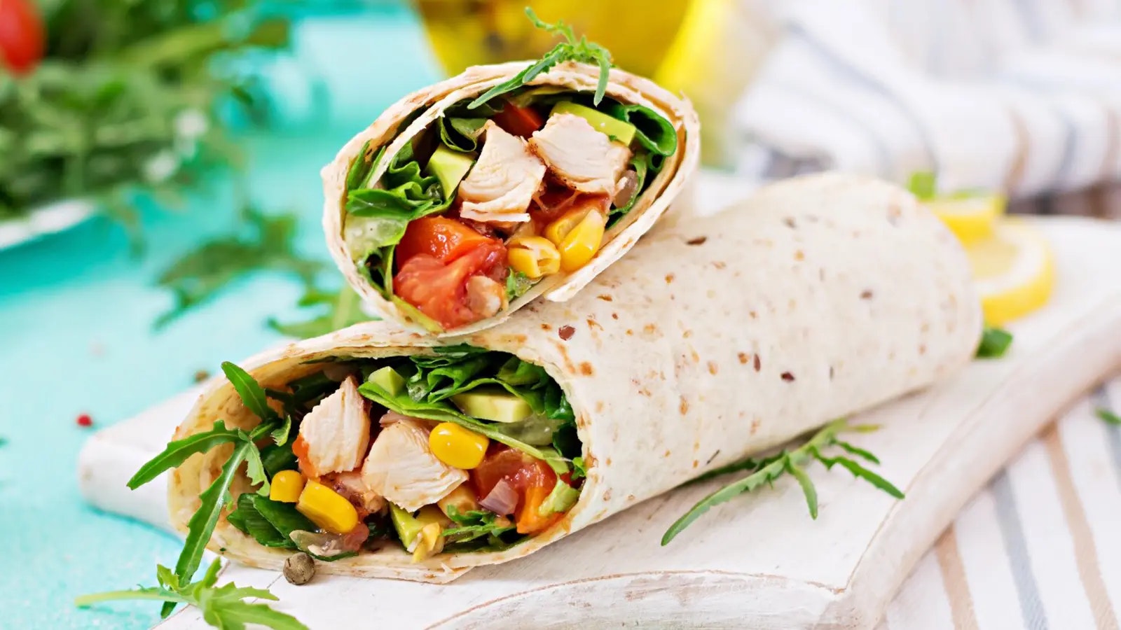 Rezept für Protein Wraps - Bild von zwei Wraps mit Füllung auf einem Holzbrett.