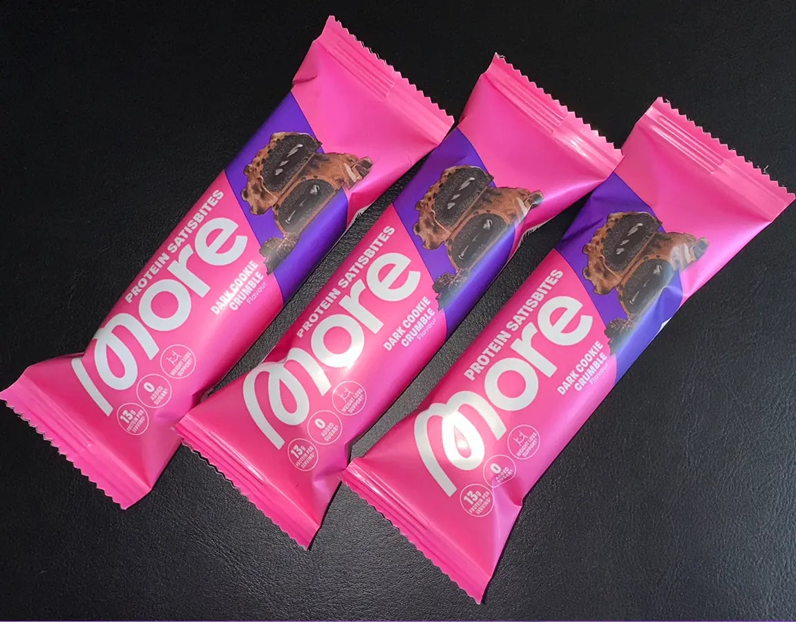 Drei More Protein Satisbites nebeneinander auf schwarzem Grund.