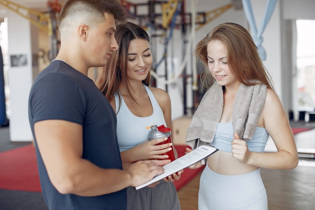 Drei Menschen, die über einen Trainingsplan sprechen