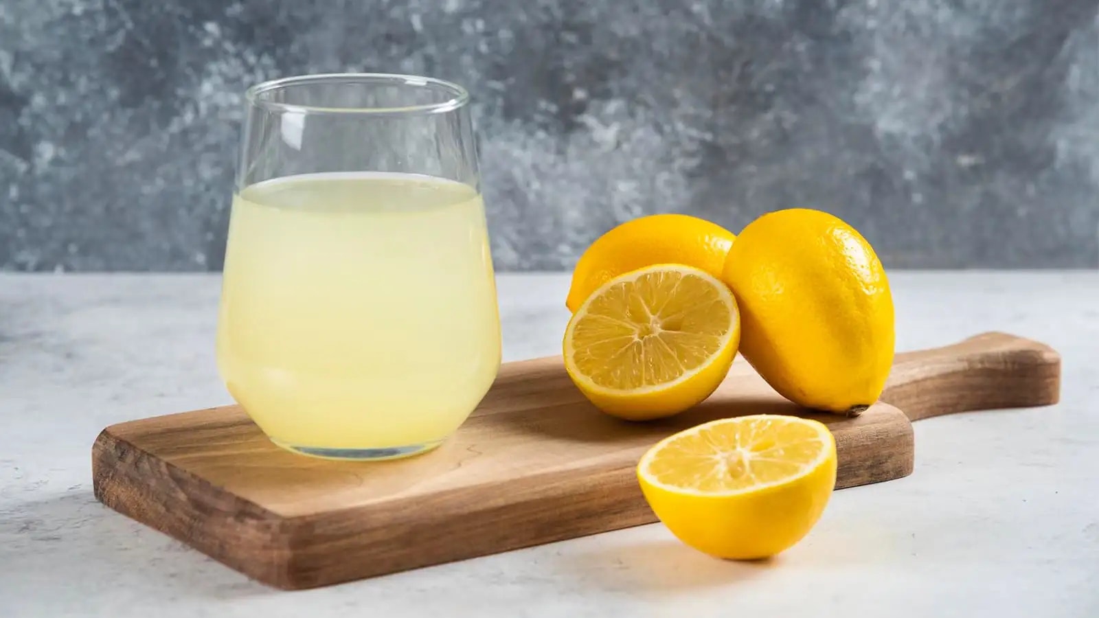 Bild von frischen Zitronen und einem Glas Zitronensaft.