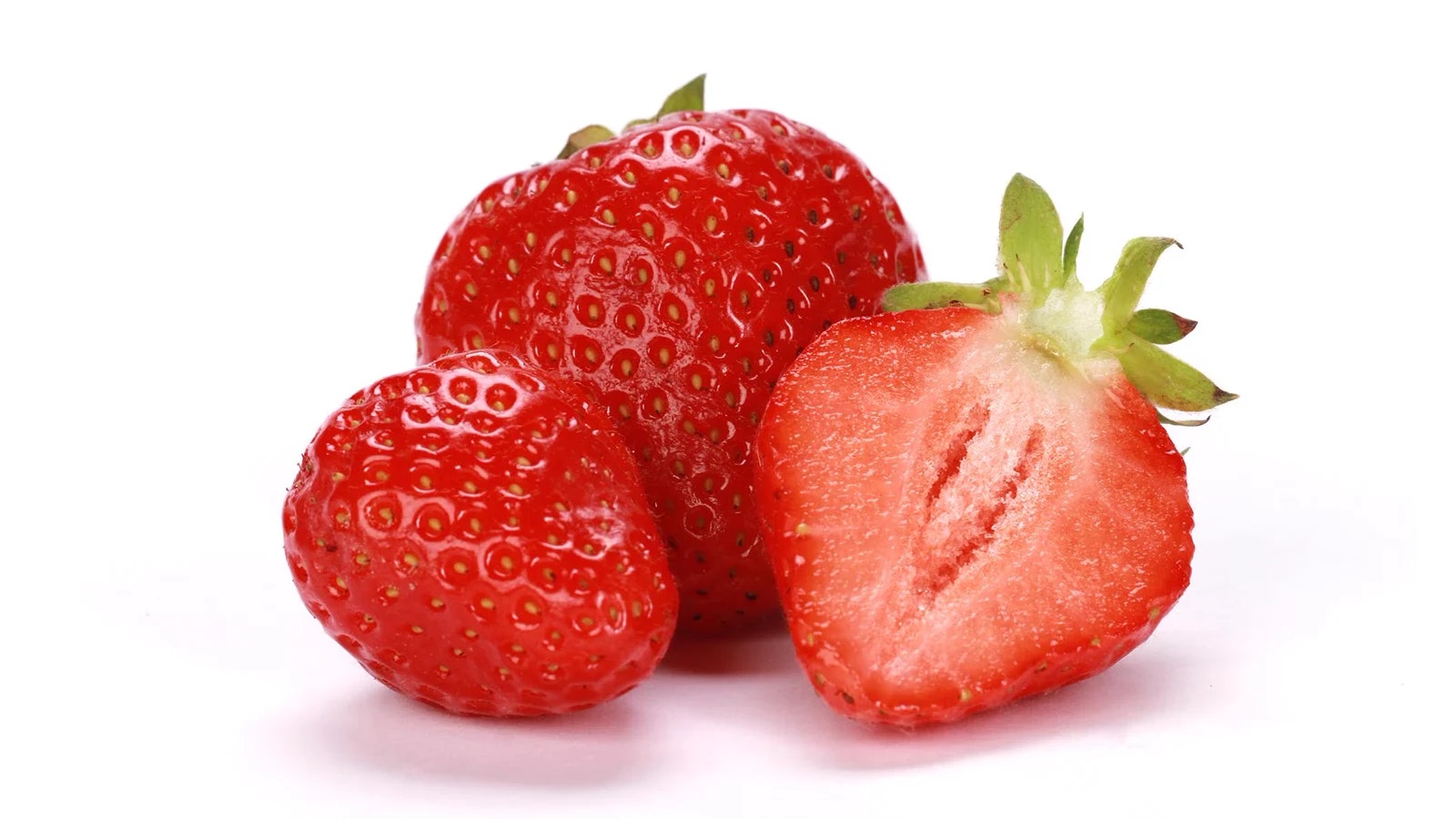 Drei Erdbeeren vor einem weißen Hintergrund.