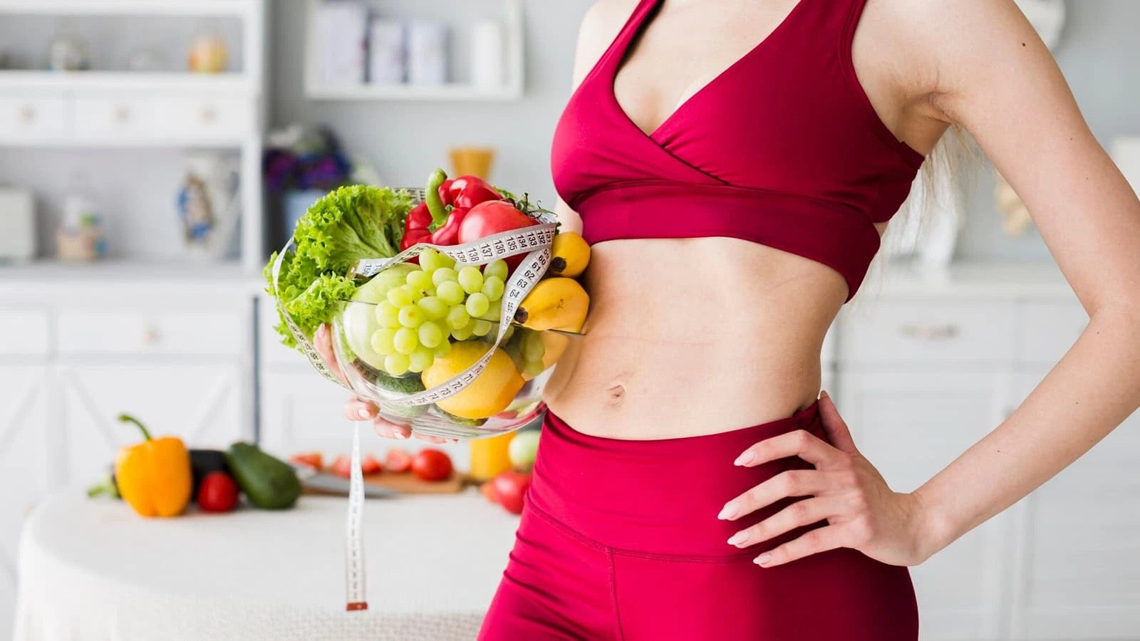 Bild von einer sportlichen Frau mit einer Schüssel voller Obst.