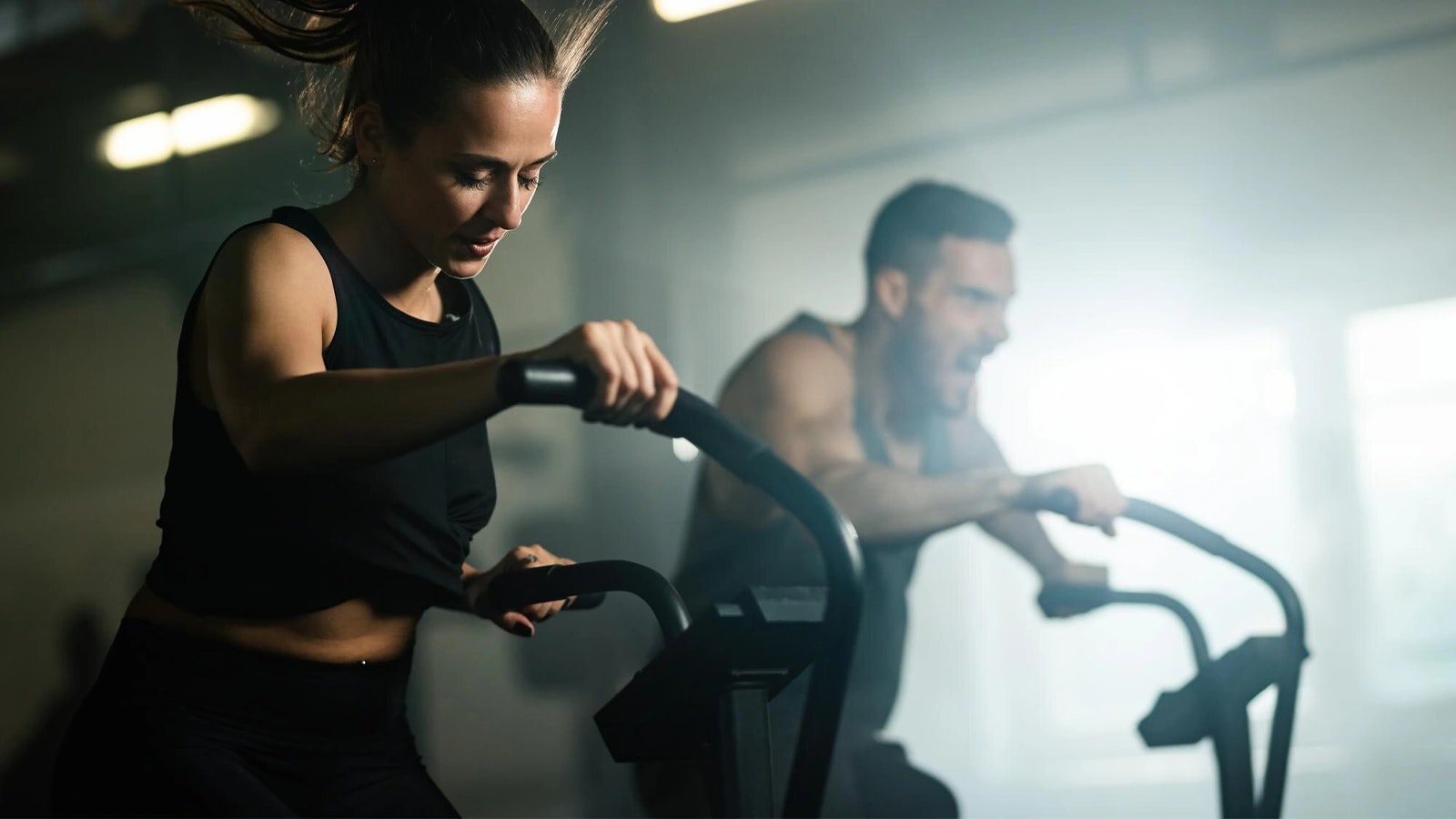 Bild von zwei Personen, die Cardio Training auf einem Crosstrainer machen.