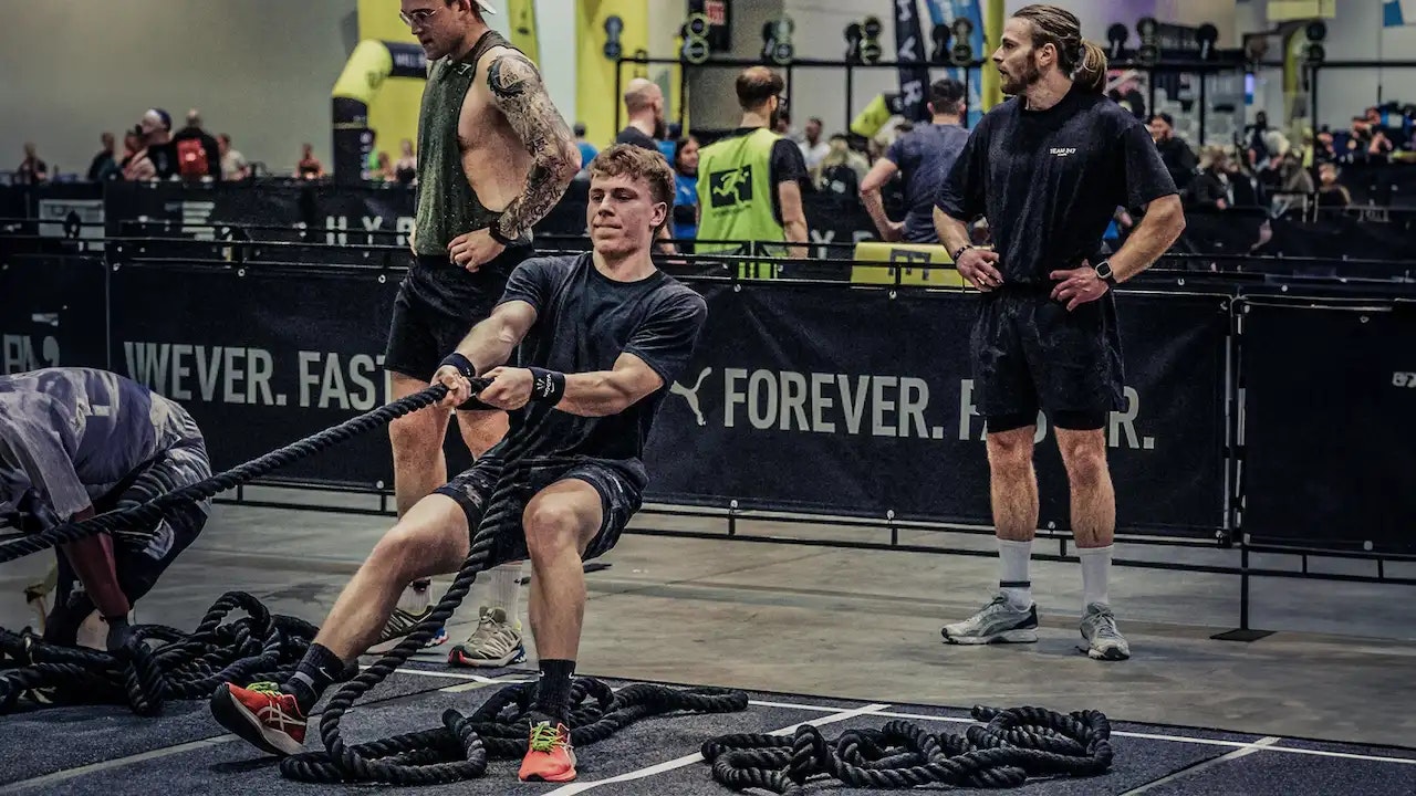 Zwei Jungs die beim Hyrox Wettkampf den Sled Pull ziehen