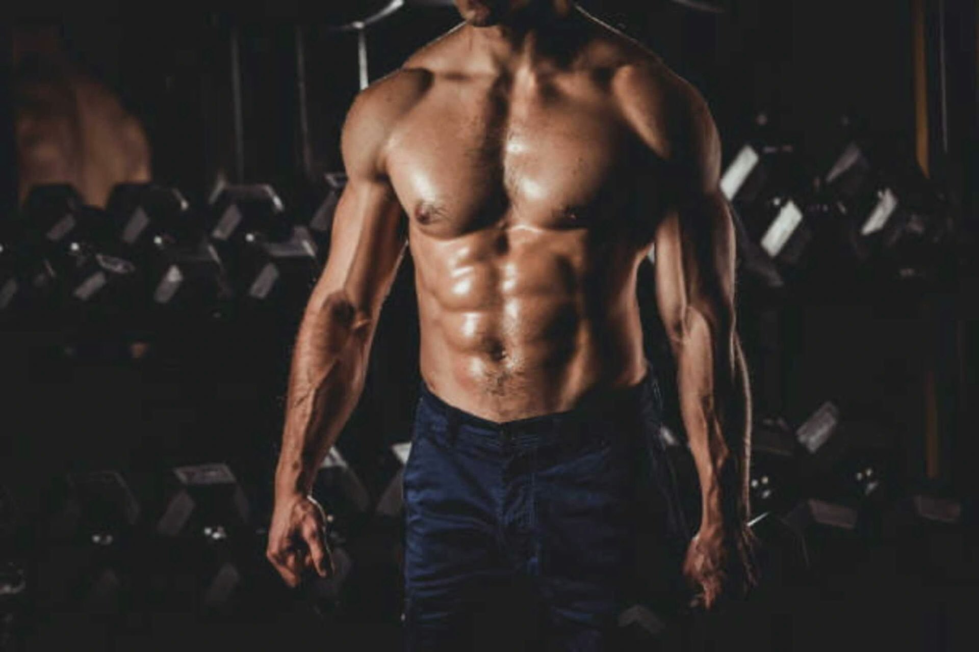 Bild von einem Mann mit Sixpack in einem Fitnessstudio.