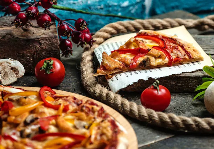 Low Carb Thunfisch Pizza auf einem Holzbrett mit Tomaten