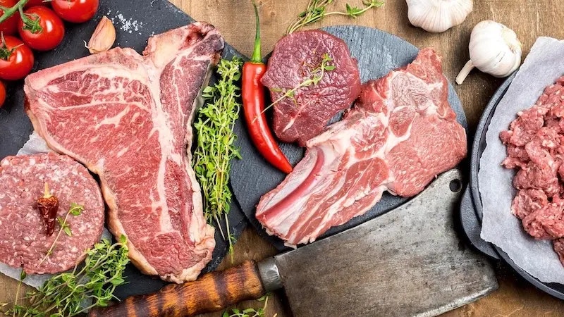 Bild von einem Tisch voller Fleisch und anderen Zutaten.