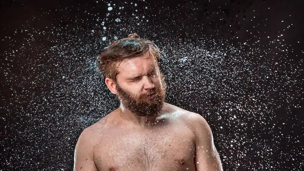 Bild von einer nassen Person, die sich schüttelt.