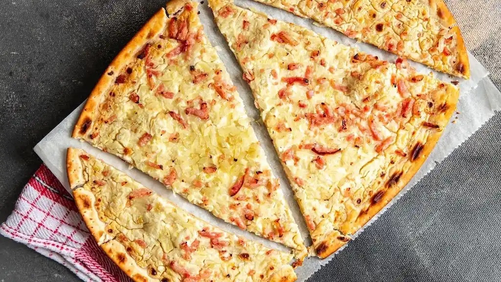 Bild von einem Low Carb Flammkuchen, der in Stücke geteilt wurde.