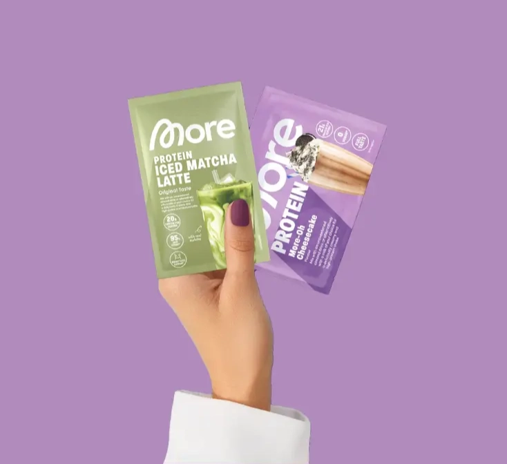Eine Hand die More Protein Iced Matcha Latte Proben in der Hand hält.