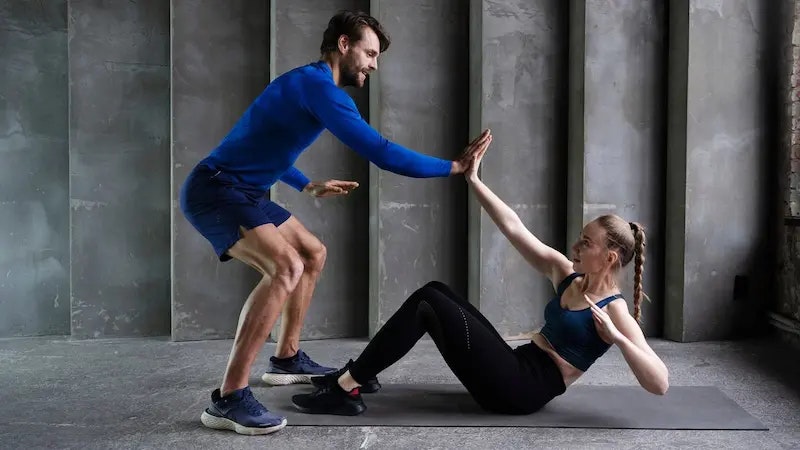 Die Rumpfmuskulatur stärken mit Core Training. Bild von zwei Personen, die Core Training machen.