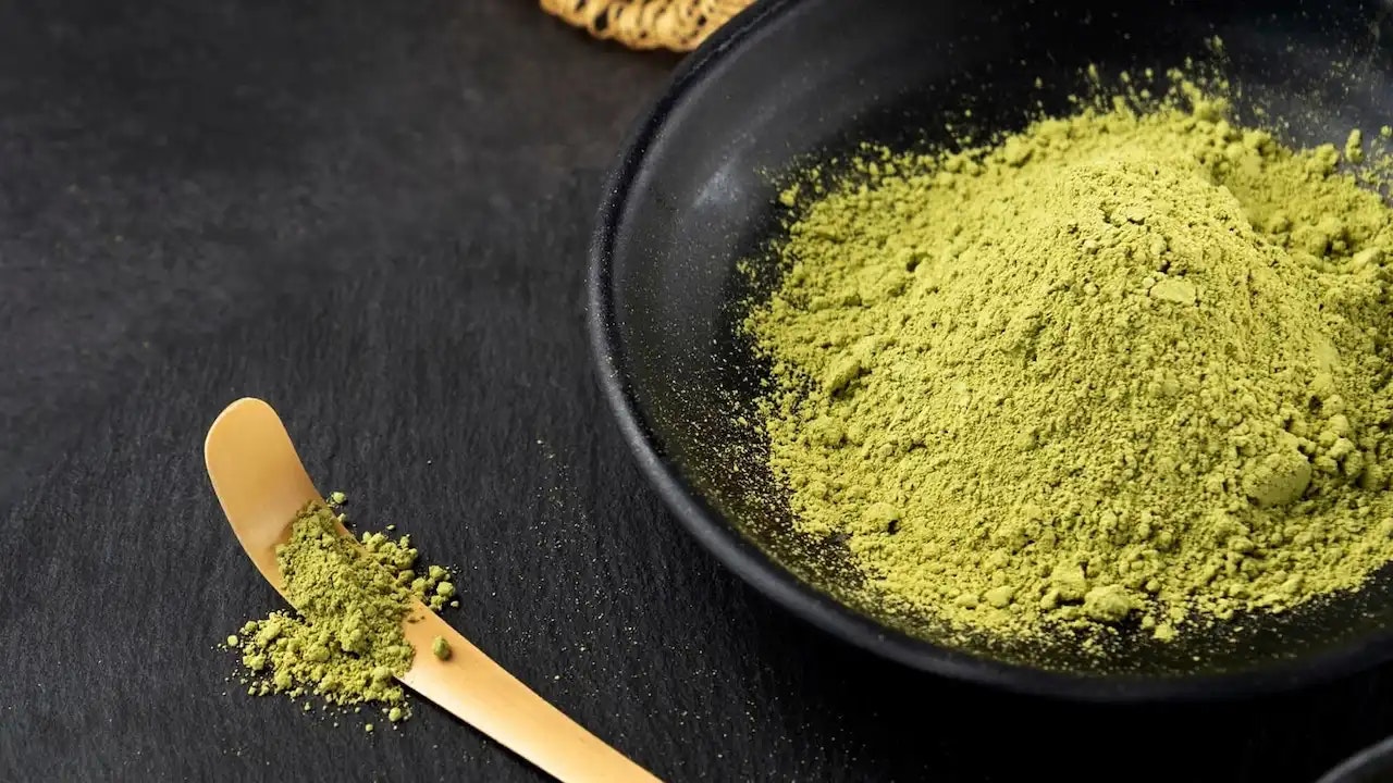Eine dunkle Schale voll mit grünem Matcha-Pulver.