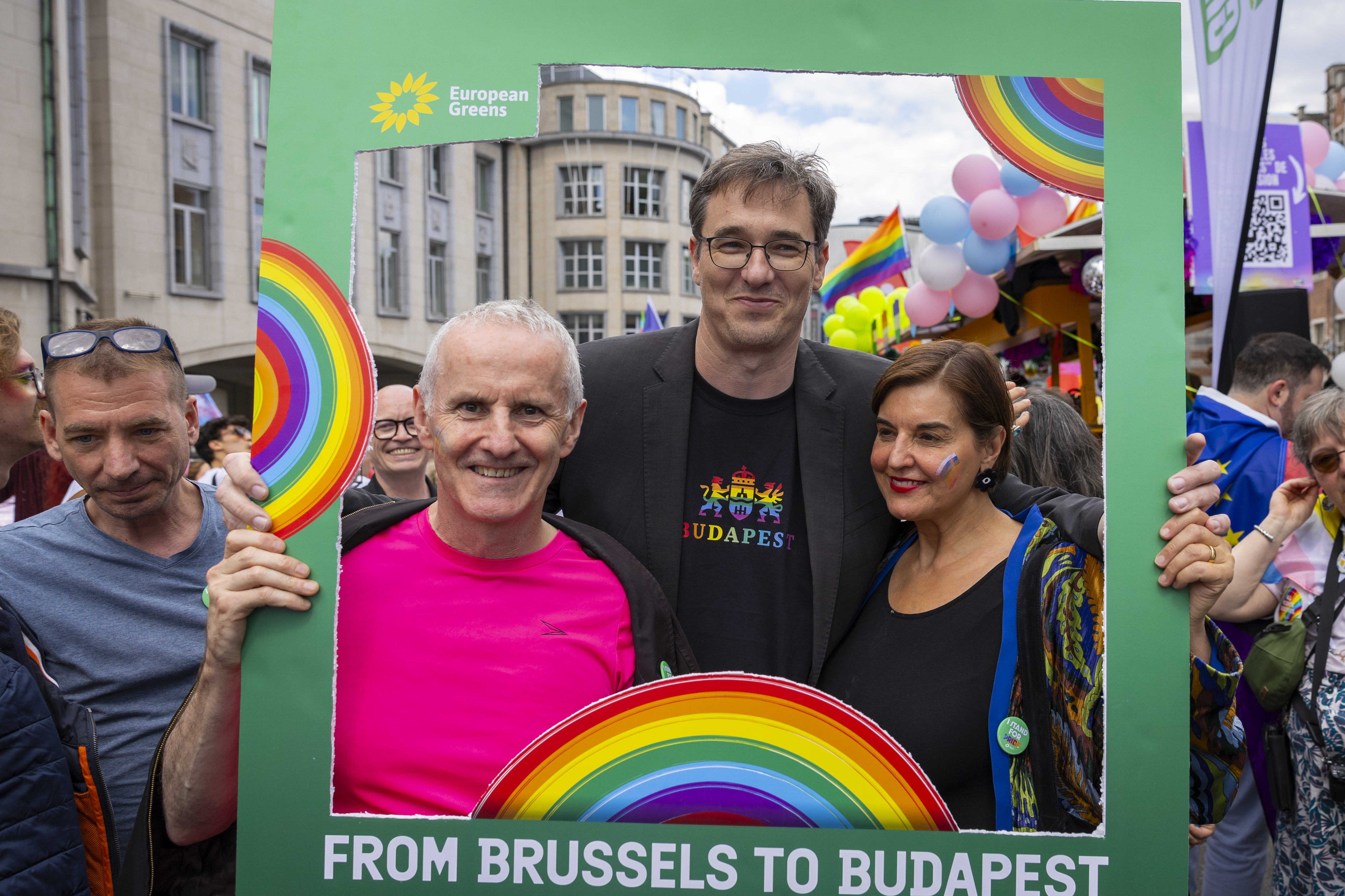 EGP Co-chairs Ciarán Cuffe and Vula Tsetsi with Gergely Karácsony, Green Mayor of Budapest, holding a sign saying "From Brussels to Budapest with Love"at the Brussels Pride