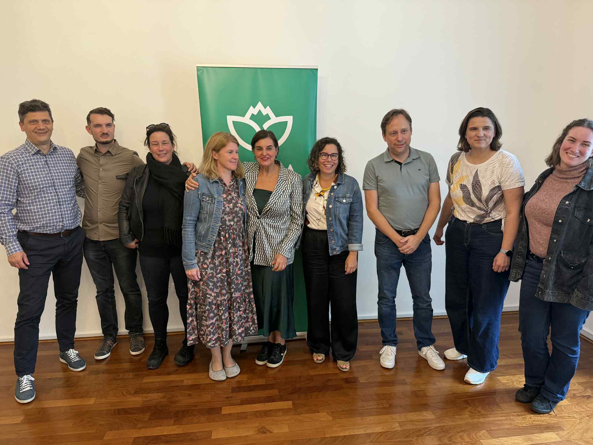 EGP Delegation and Vesna representatives standing in a room smiling for a family photo, with Vesna's logo in the background.