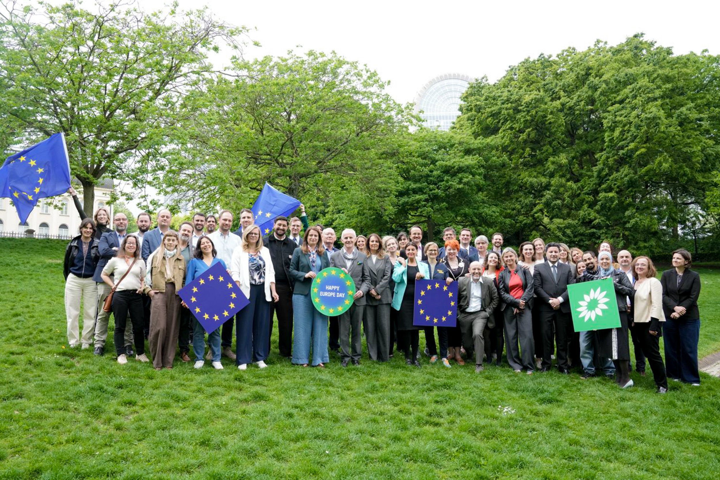 Group of Green leaders, wide group photo in a park, with people holding EU flags, sunflower signs