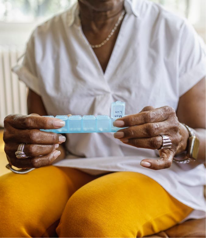 woman looking at a pill container