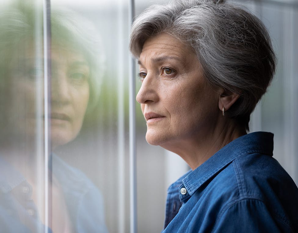 sad woman looking out a window