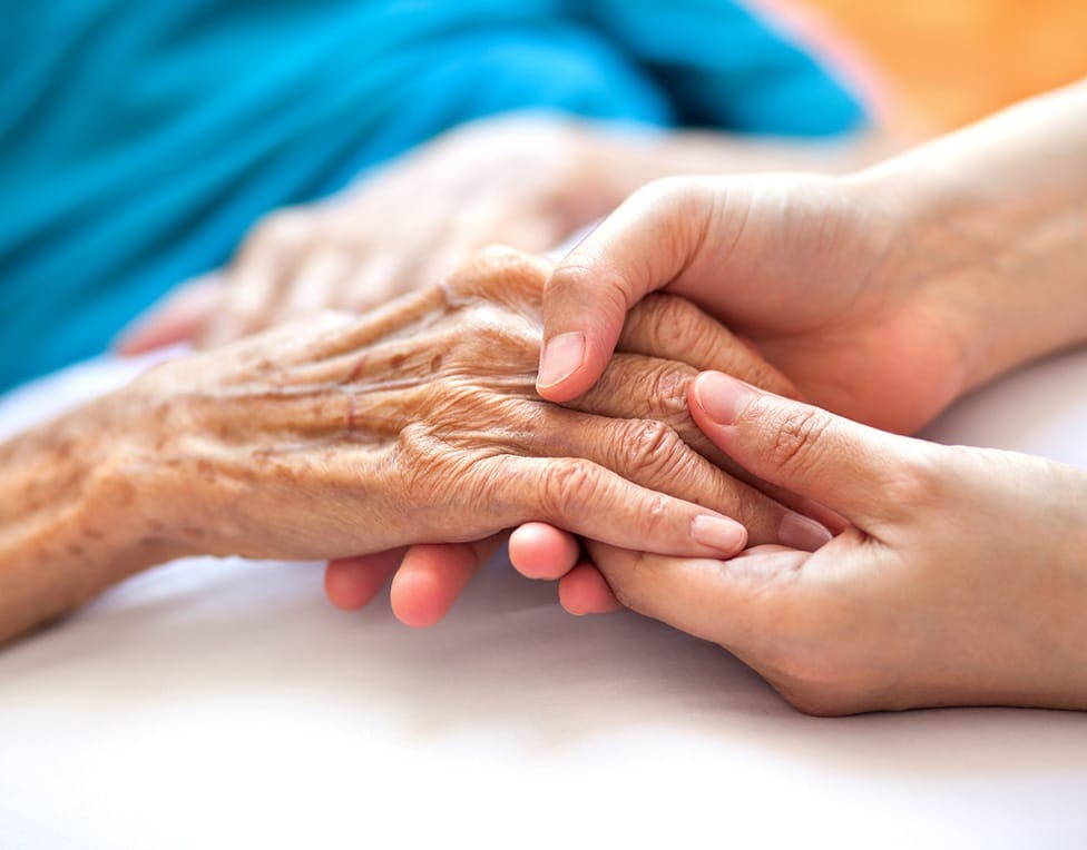 young and old person holding hands