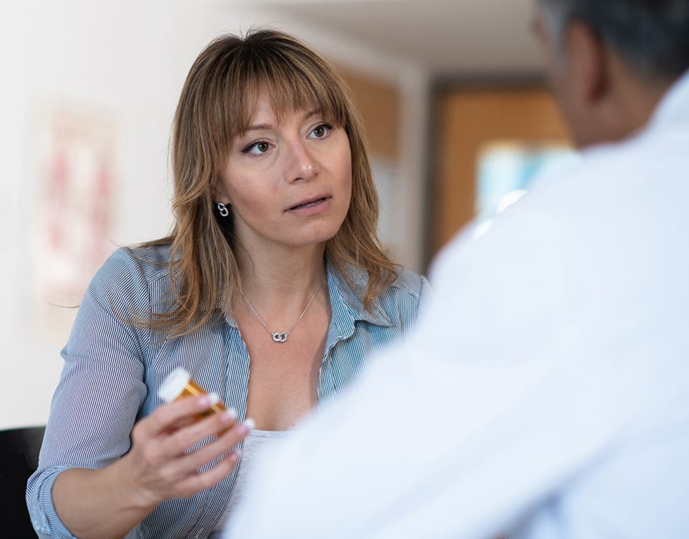 Woman holding medicine up to someone