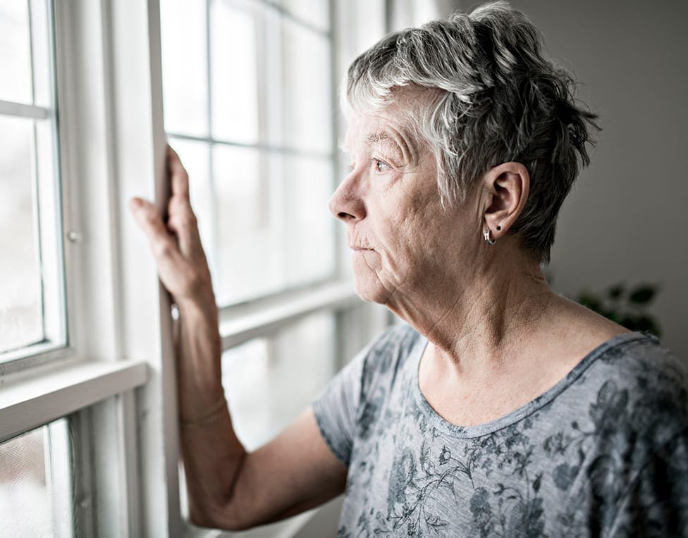 elderly woman looking out a window