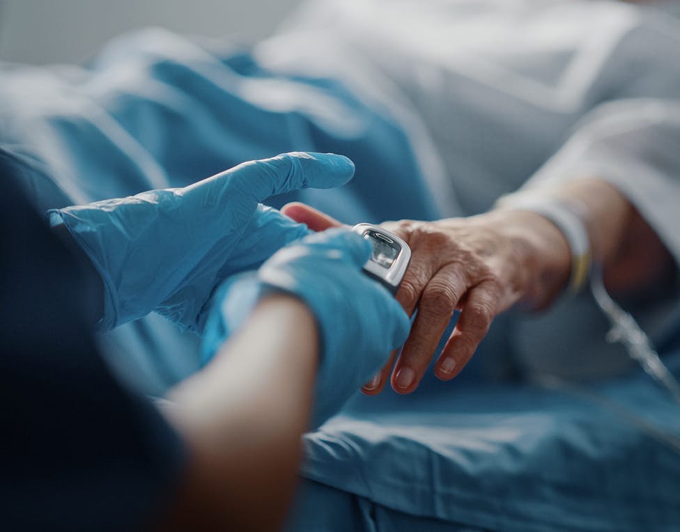 nurse putting an oxygen monitor on a patient