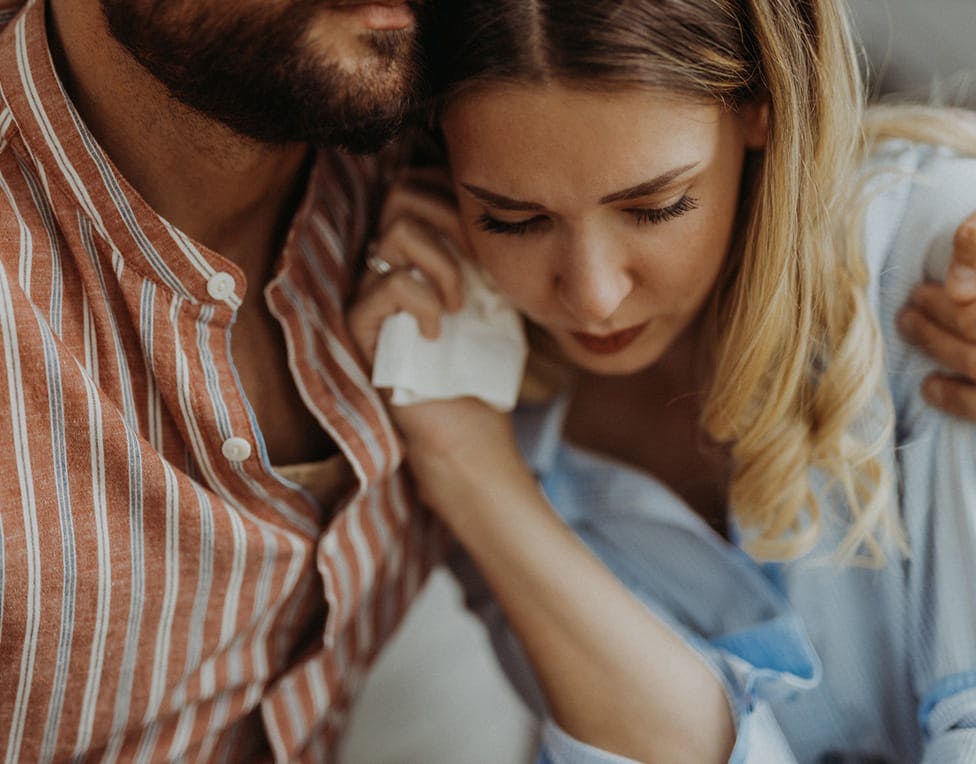 two people holding each other in grief