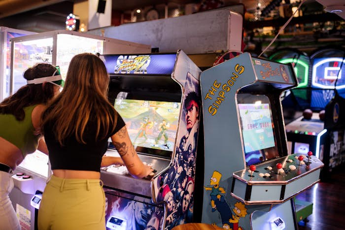 two women playing street fighter arcade game