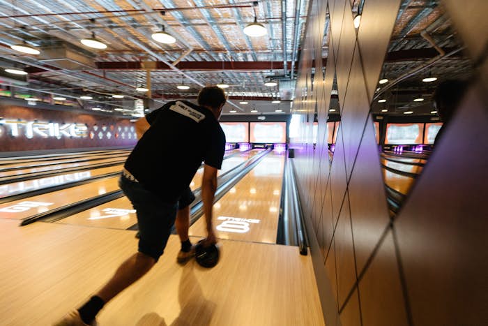 Man approaching bowling lane with bowling ball ready to throw