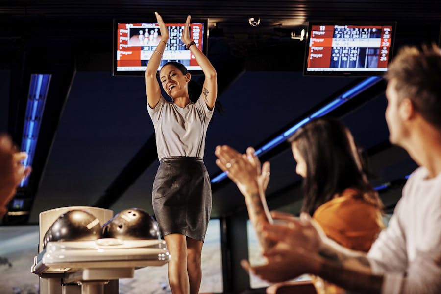 Woman celebrating bowling with friends