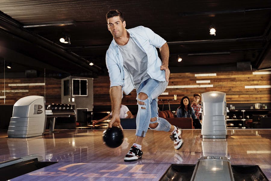 Man releasing bowling ball onto the lane