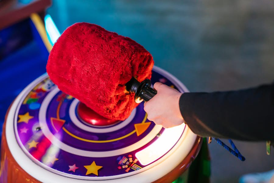 Person playing hammer arcade game