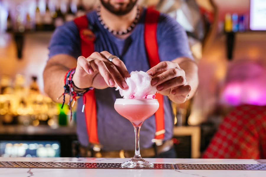 Bartender adding fairy-floss on top of The Circus Sour cocktail