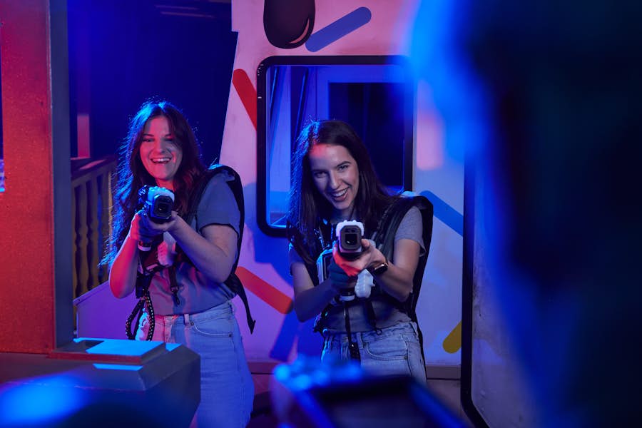 Two women holding laser tag guns ready to shoot