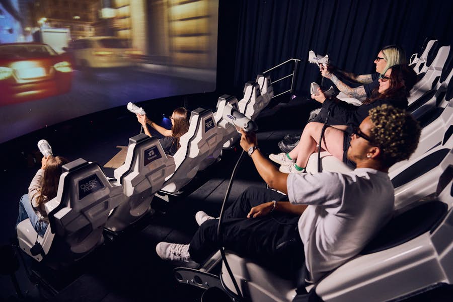 People pointing laser guns toward interactive theatre screen