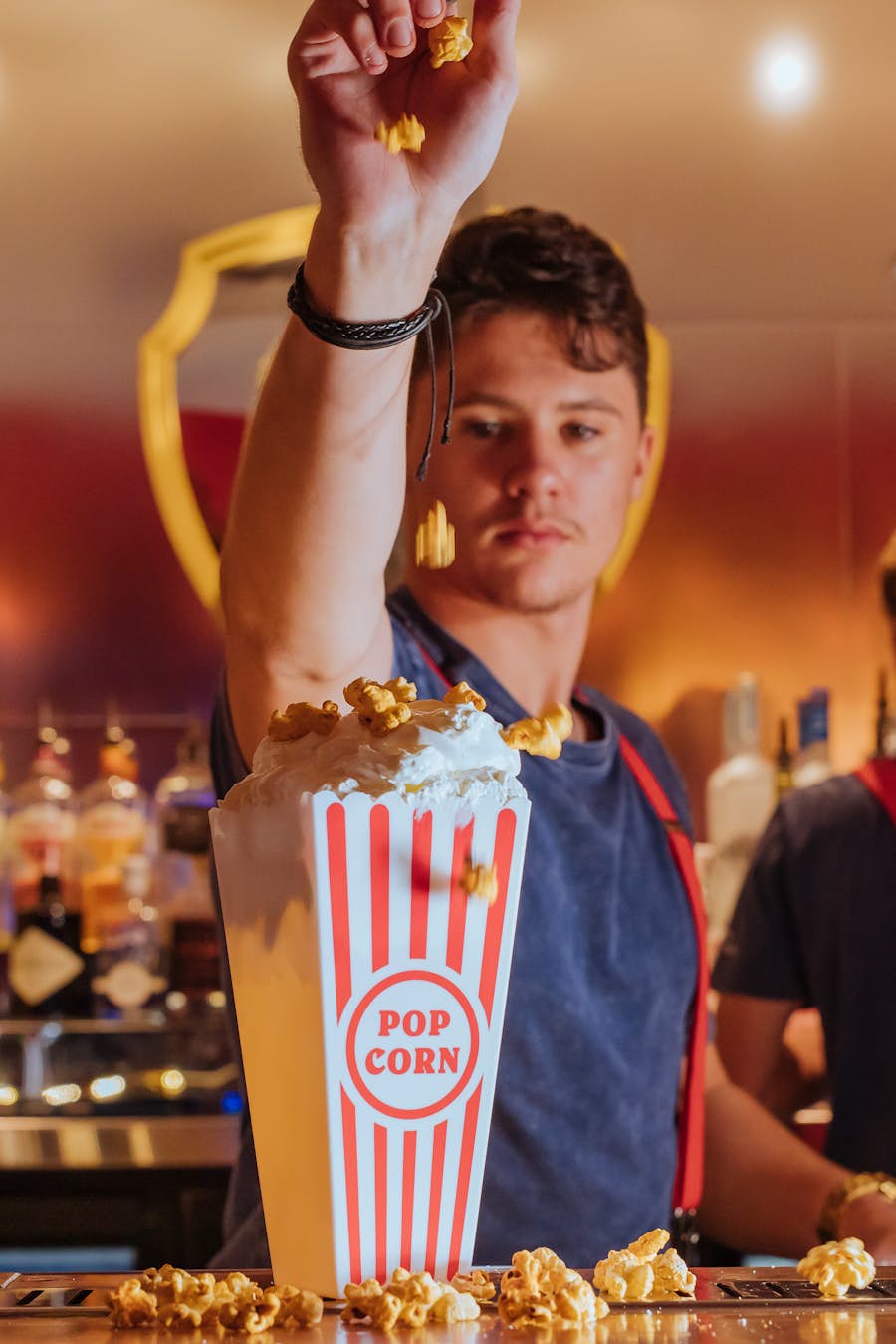 Bartender dropping popcorn into popcorn bucket