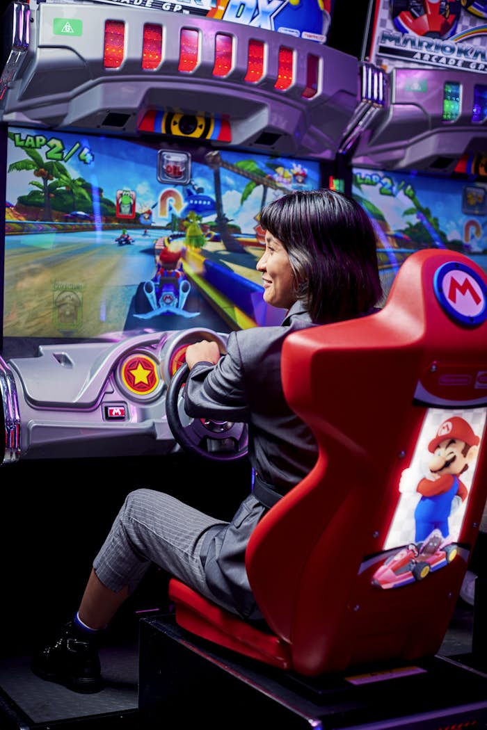 Woman playing Mario Kart arcade game
