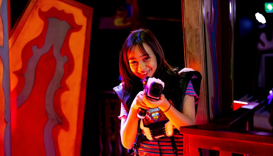 Girl holing up and pointing a laser tag gun