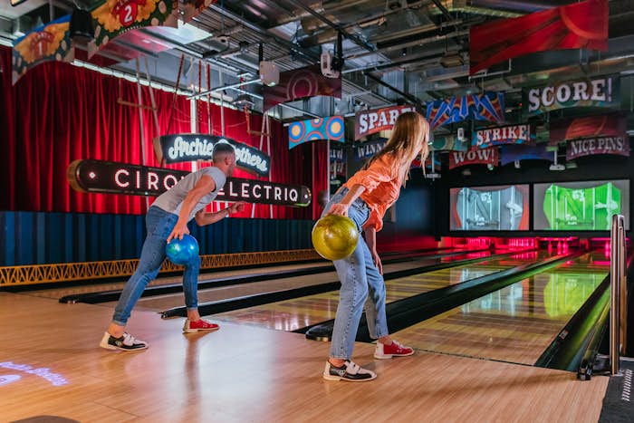 A man and woman bowling together at Archie Brothers Cirque Electriq