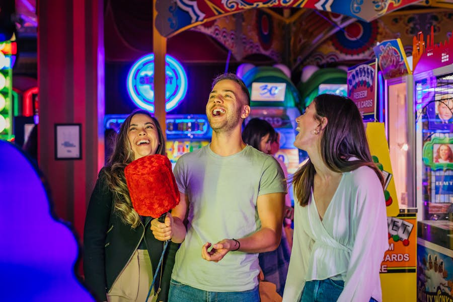 Group of people celebrating while playing arcades at Archie Brothers Cirque Electriq