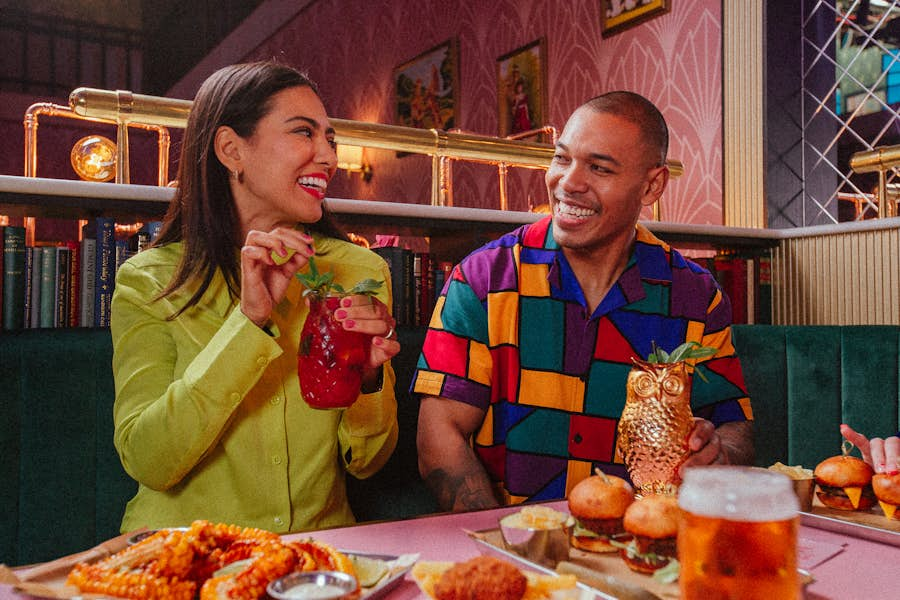 Man and woman laughing while holding Strawberry Mojito