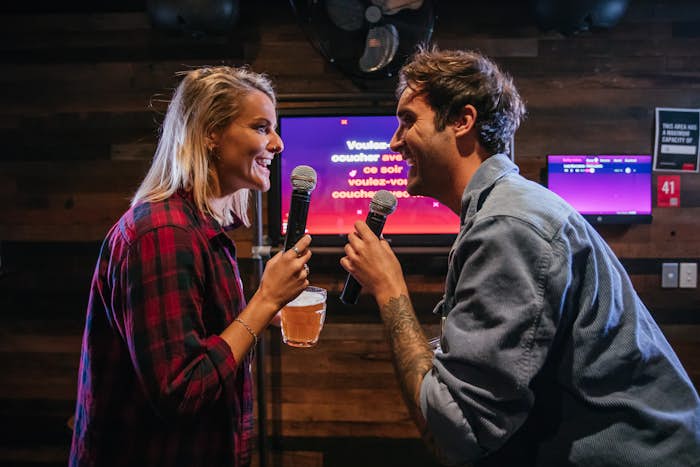 Man and woman singing karaoke at Strike