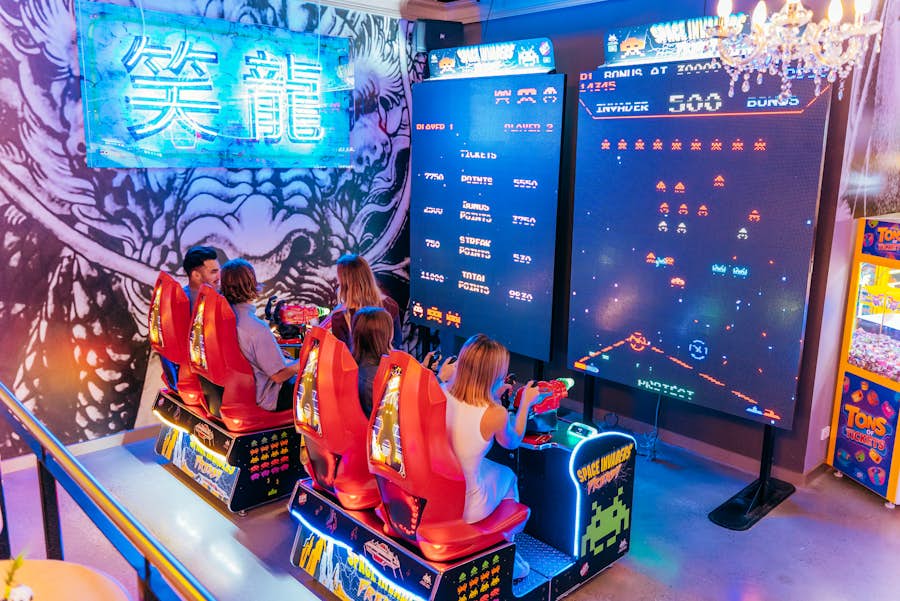 Group of 4 playing space invaders arcade game