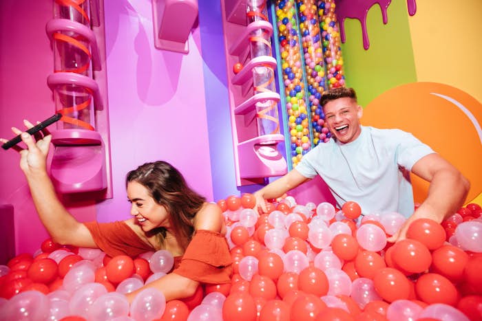 Guy and girl playing ball pit challenge room at Hijinx Hotel in Chermside