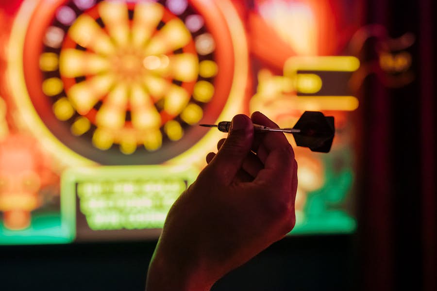 hand holding dart in front of interactive dartboard at la di darts