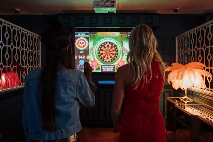 two women lining up their shots at la di darts interactive darts