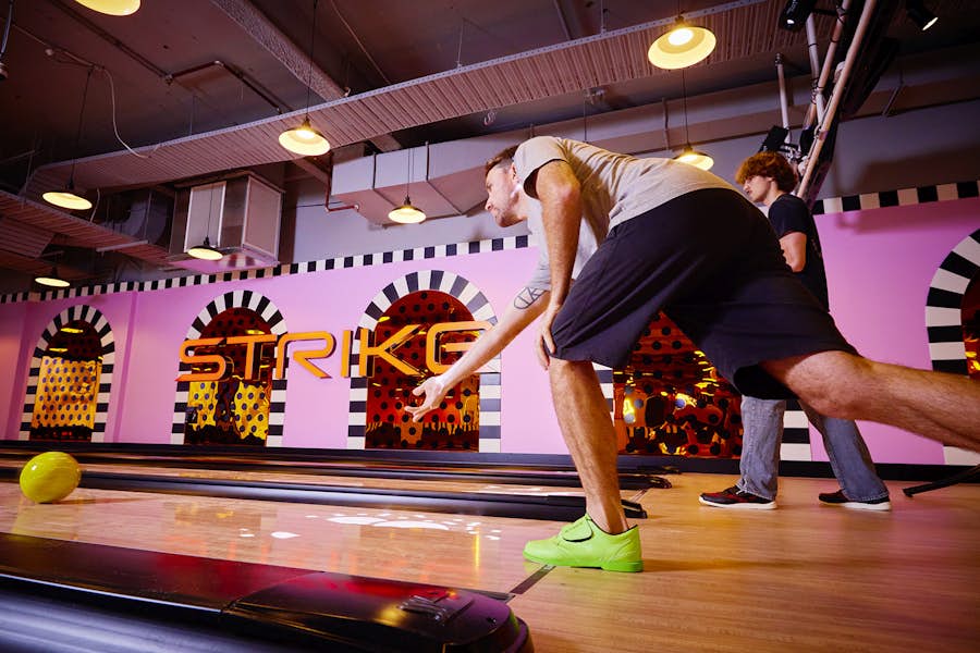 Man releasing bowling ball onto the lanes