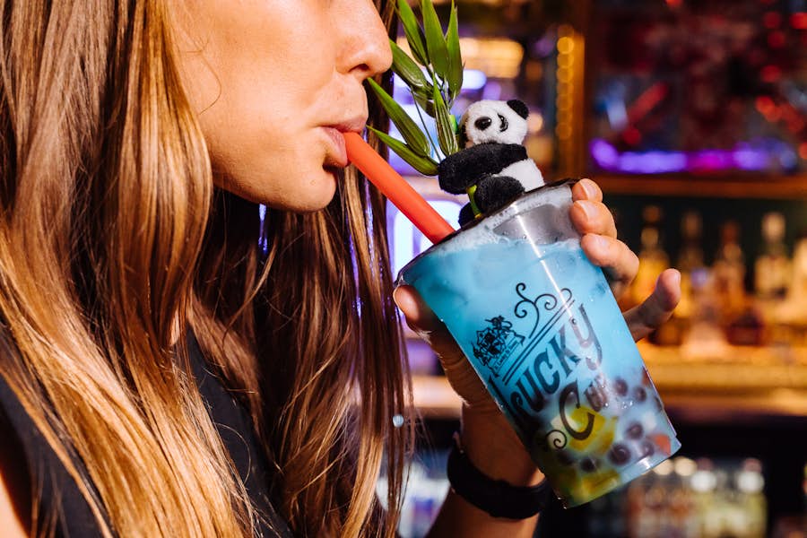 Close up of a woman drinking the Berry Pop Bubble Cup cocktail