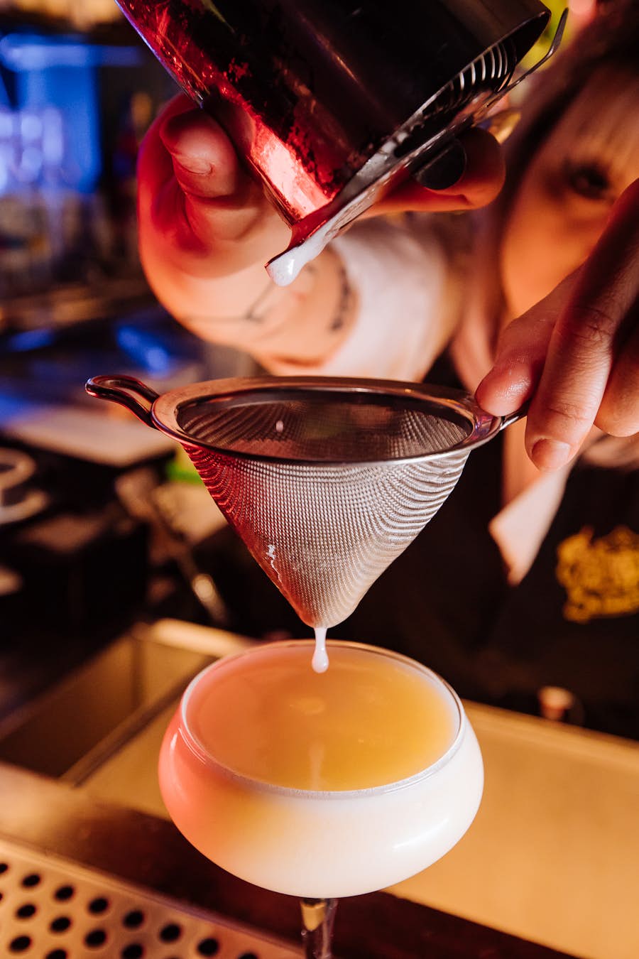 Bartender preparing a White Choc Drop cocktail behind the bar