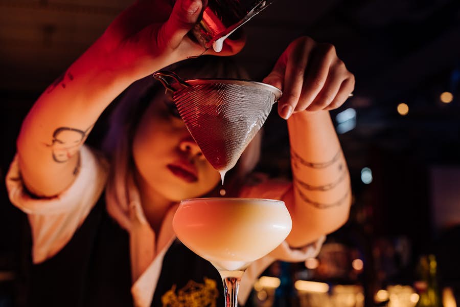 Bartender preparing a White Choc Drop cocktail behind the bar